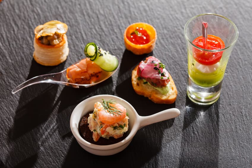 Kanapees, Löffelhappen und ein Gemüsegläschen als Fingerfood auf Schiefer
