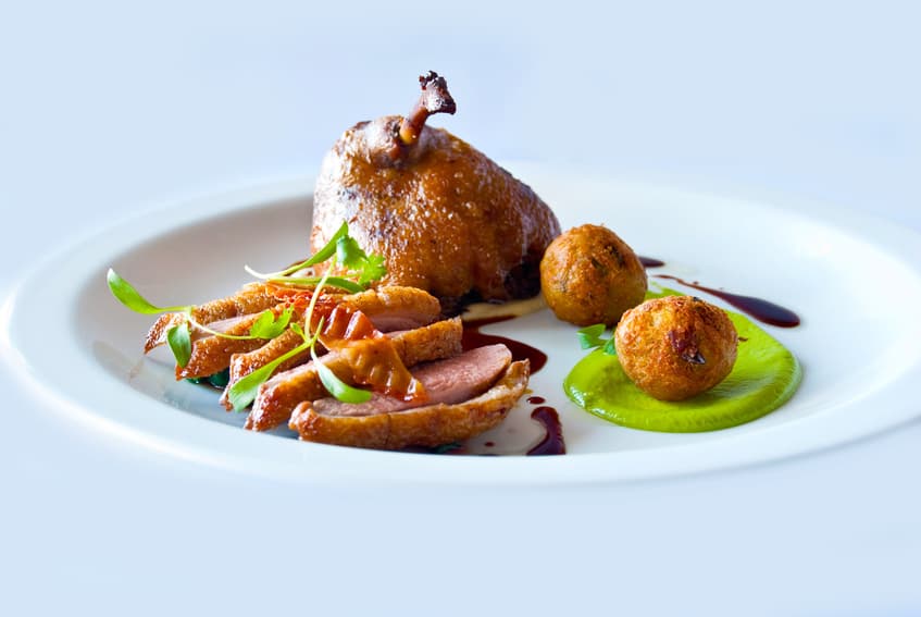 Gebratene Entenbrust und Keule mit grünem Püree und Kroketten