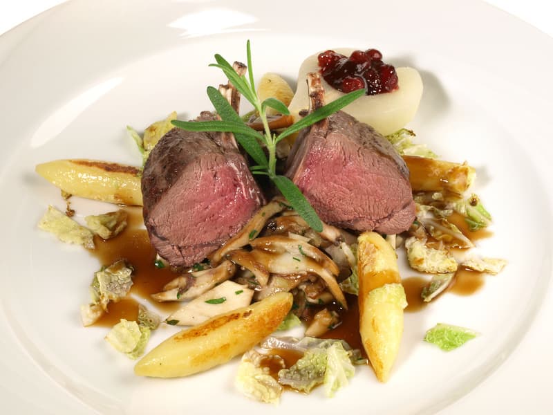 Rosa gebratenes Fleisch mit Pilzen, Wirsing, Schupfnudeln und Preiselbeeren