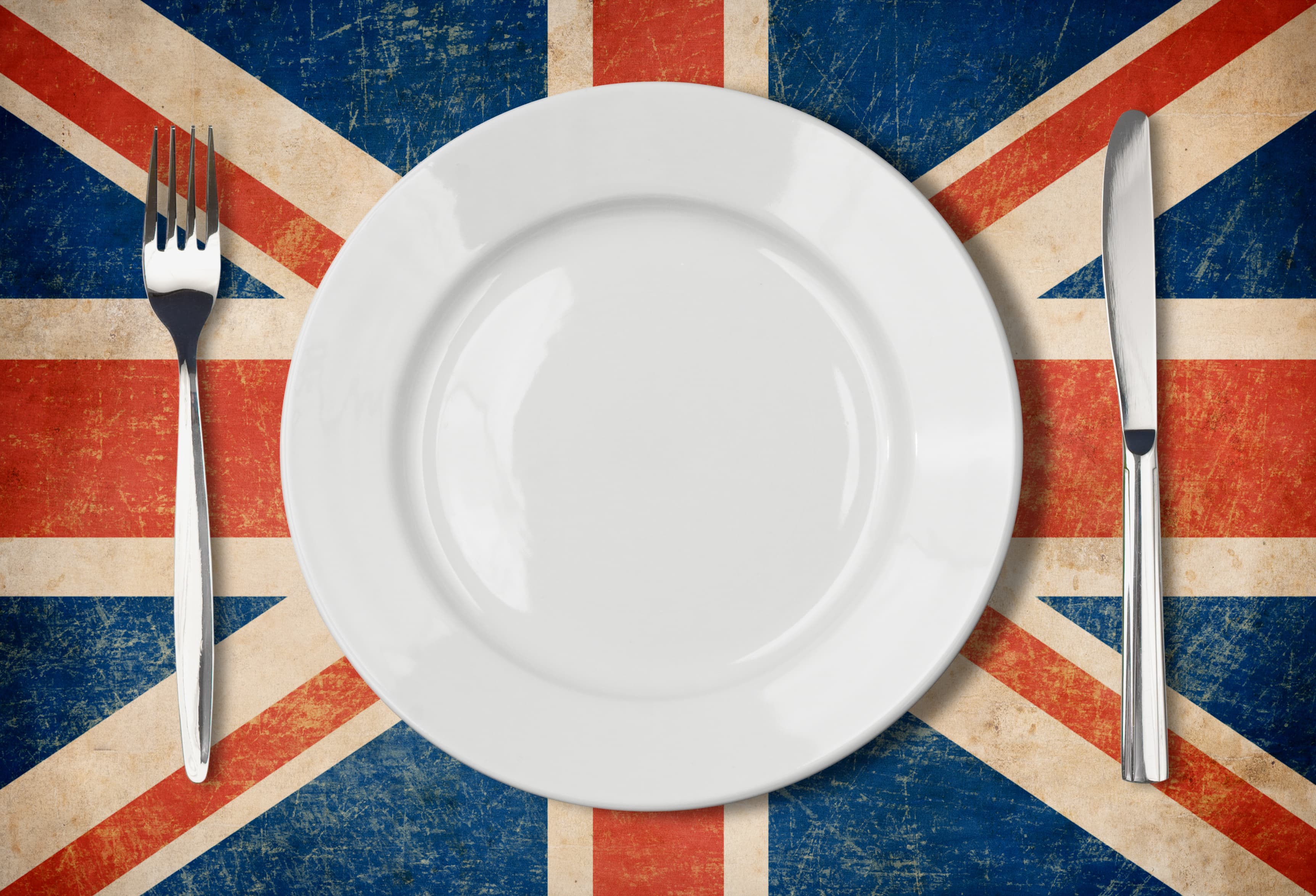 Weißer Teller mit Gabel und Messer auf britischer Flagge
