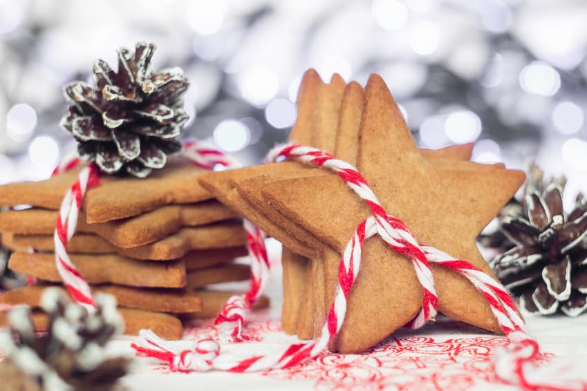 Sternförmige Lebkuchen mit rot-weißer Schnur und Tannenzapfen