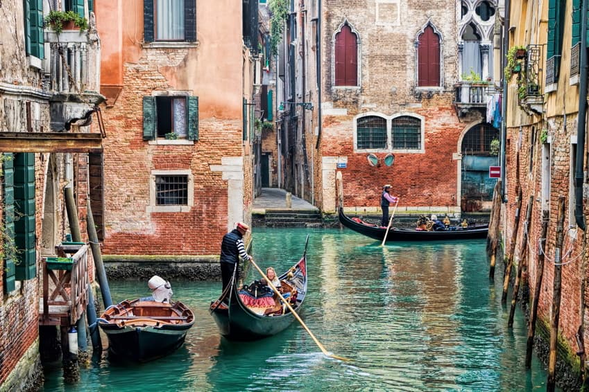 Gondeln auf einem Kanal in Venedig zwischen Backsteinhäusern